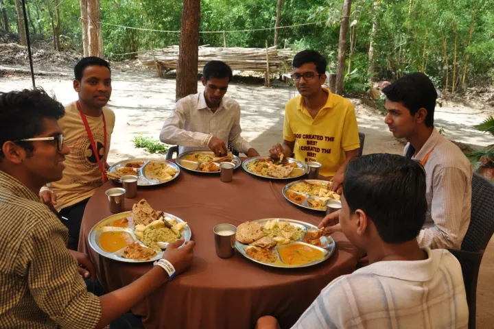 EvolveClub students sharing a meal during a community camp